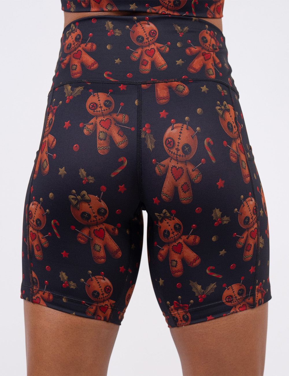 back of the gingerbread voodoo dolls with pins in them surrounded by berries and stars on a black background 7 inch shorts
