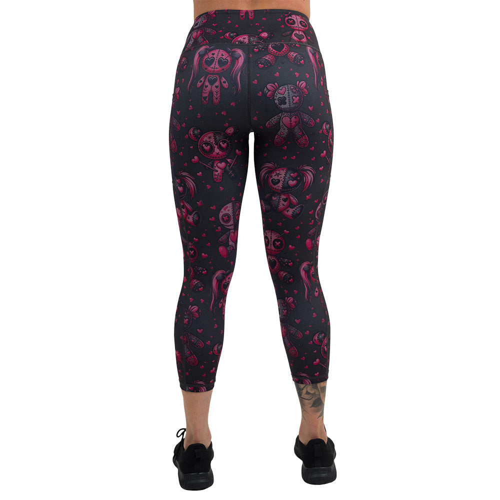  back of pink voodoo doll with pink hearts pattern capri leggings against a white background