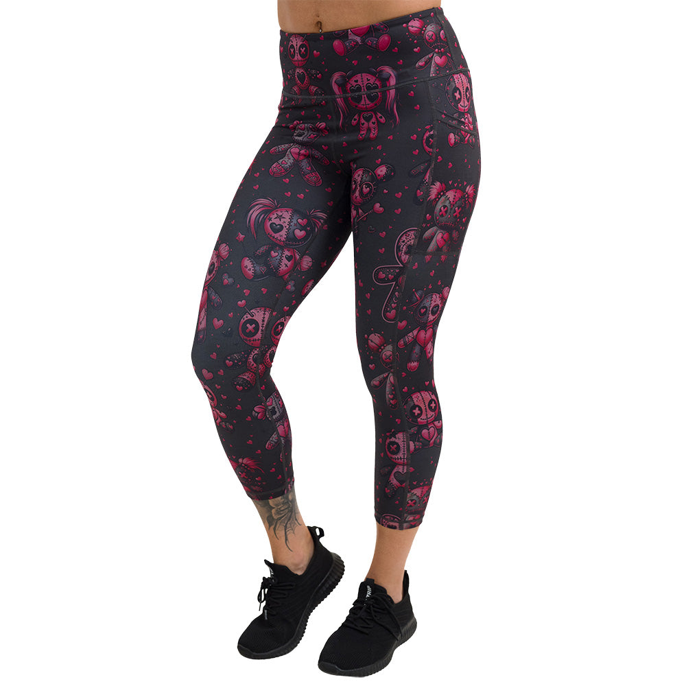 pink voodoo doll with pink hearts pattern capri leggings facing the front against a white background