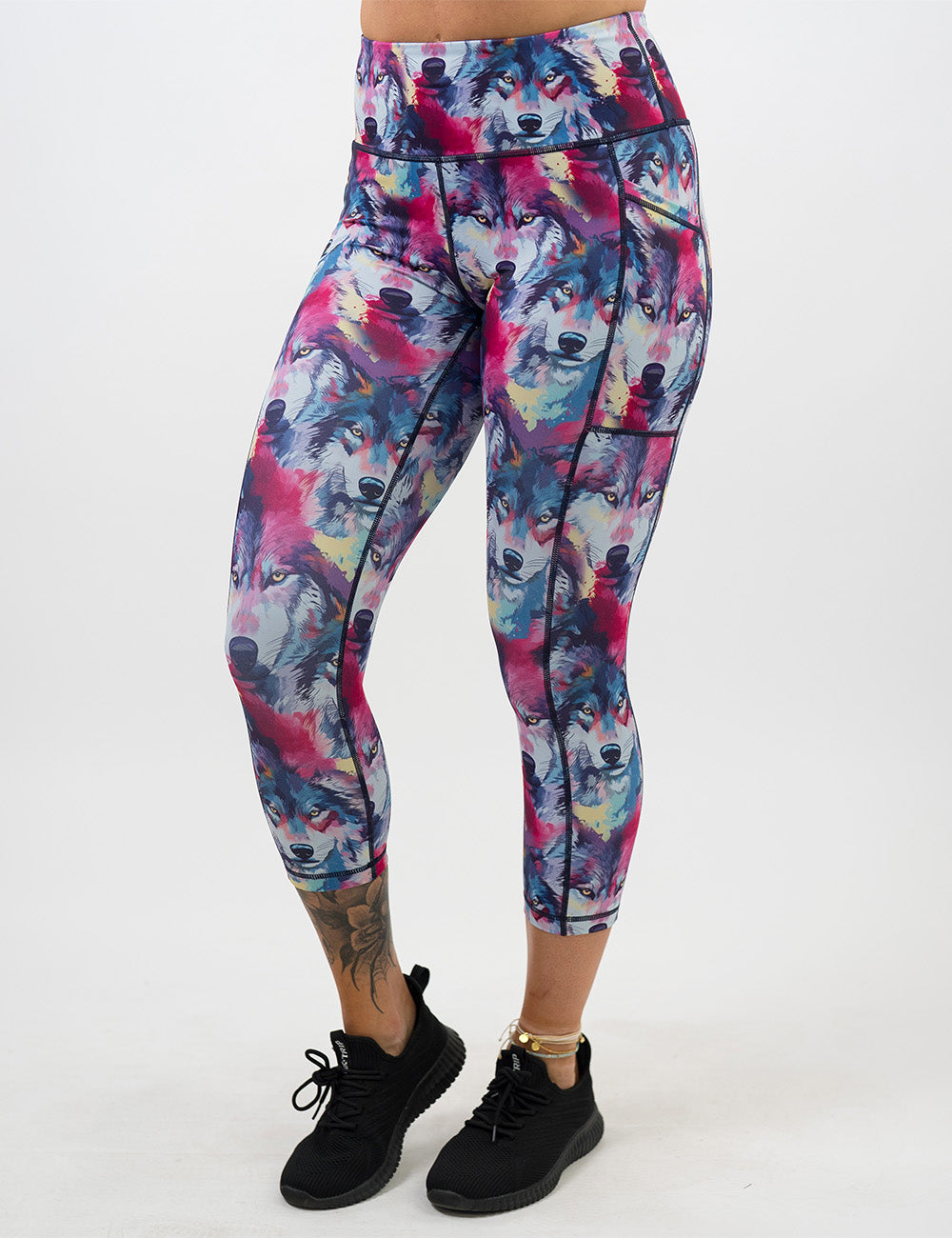 front of the red, white, blue, and yellow watercolor style wolves capri leggings against a white background