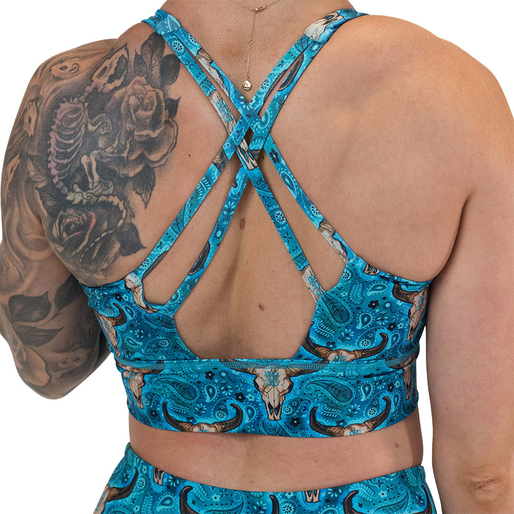 back of the teal cow skull print sports bra