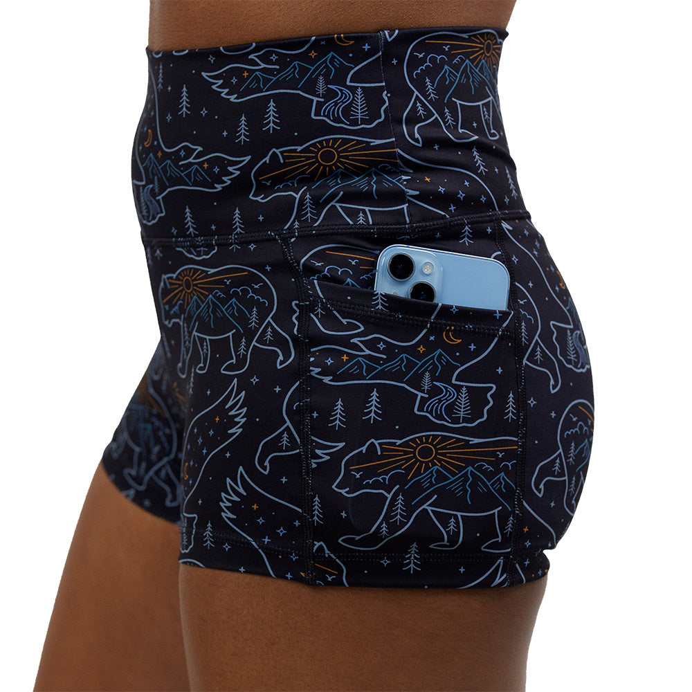bird and bear outlines against a dark background 2.5 inch shorts with a phone in is pocket against a white background