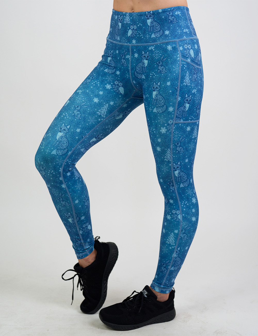 front of the blue foxes, owls, and bunnies in a winter landscape full length leggings against a white background