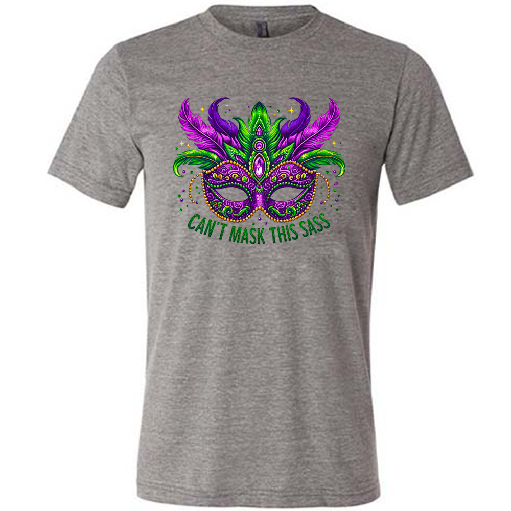 grey unisex tee with the graphic of a fancy, feathered and bejeweled, and colorful mardi gras mask, and words underneath saying "can't mask this sass"