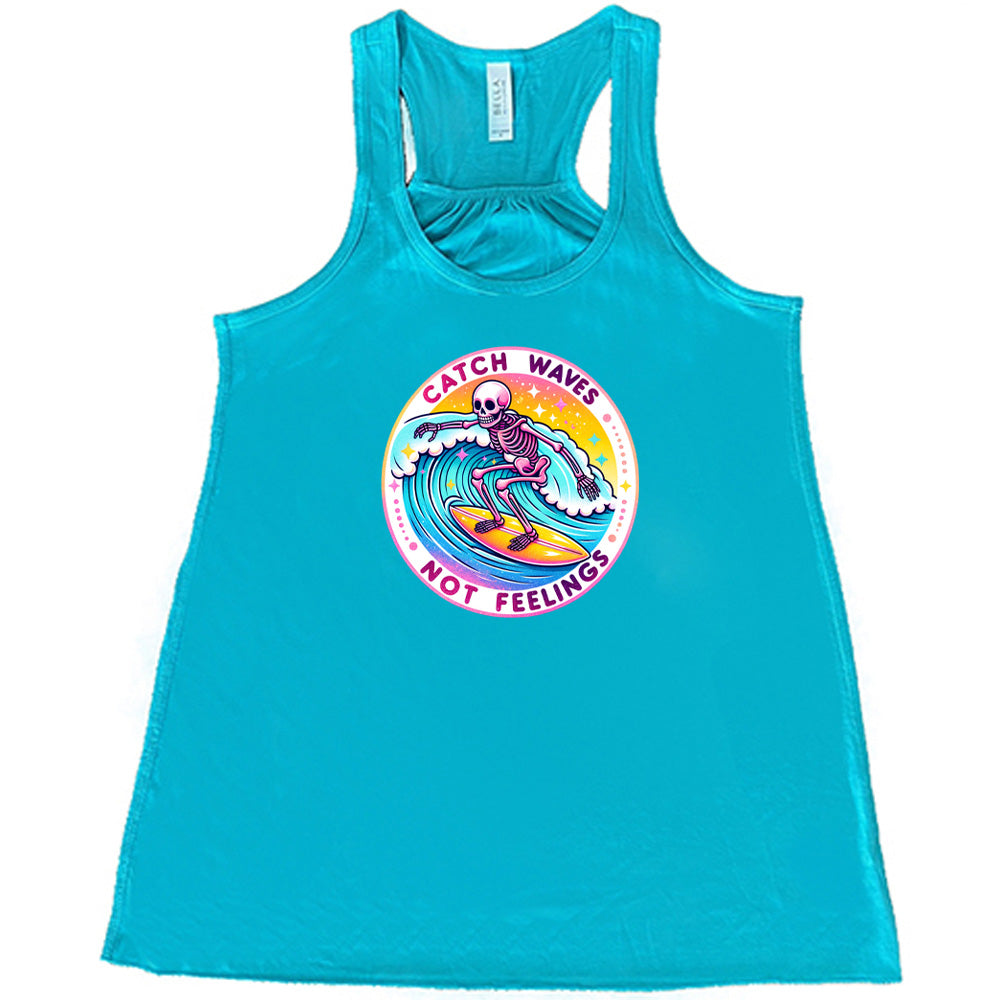 Teal colored flowy tank with a skeleton surfing graphic on it that says "Catch Waves Not Feelings" 