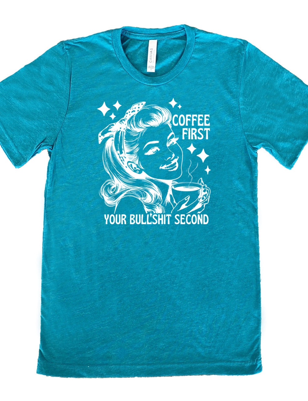 teal unisex tee with the graphic of a woman happily holding a mug of steaming coffee, with the words "coffee first" (next to her face) and "your bullshit second" underneath, and a few stars around her