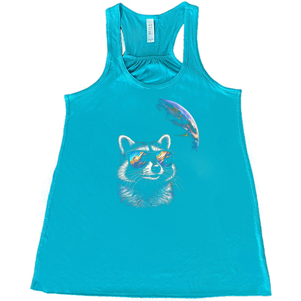Teal colored flowy tank with a raccoon looking into space graphic on it
