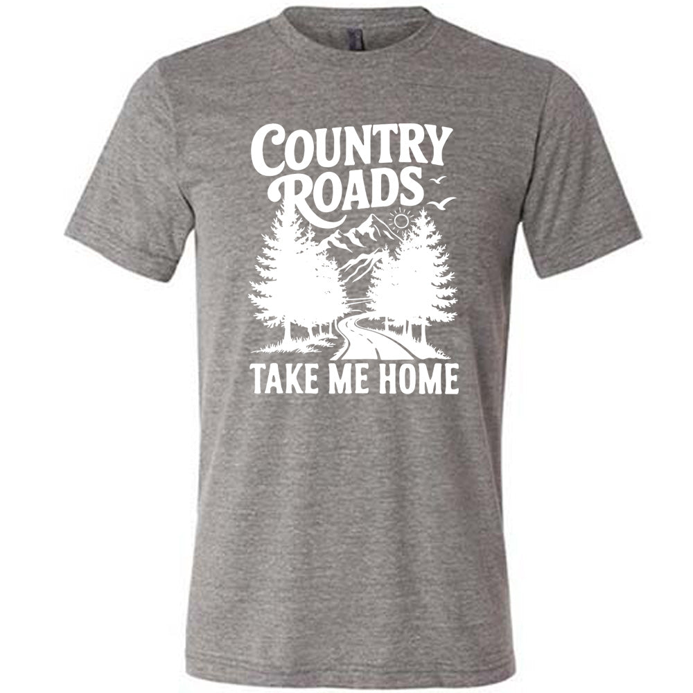 grey unisex tee with the words "country roads take me home" on it, and the graphic of a road going through tall trees, with mountains beyond, and the sun