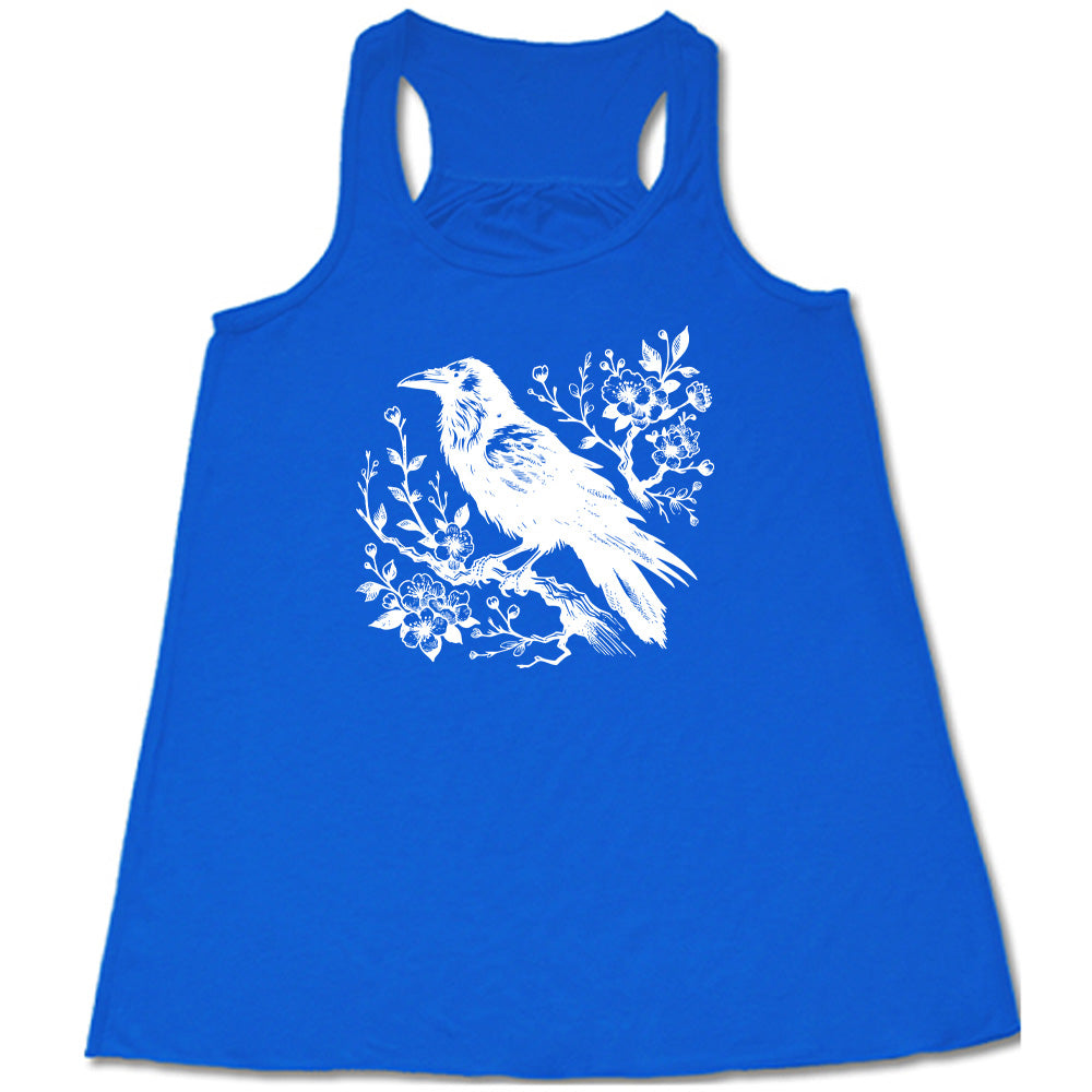 Blue colored flowy tank with crow on flowery branch graphic on it