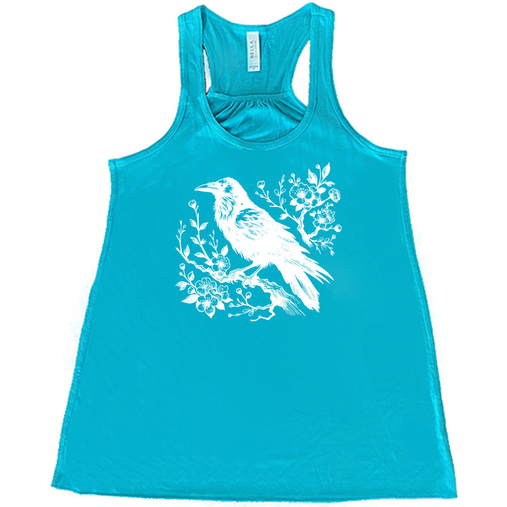 Teal colored flowy tank with crow on flowery branch graphic on it