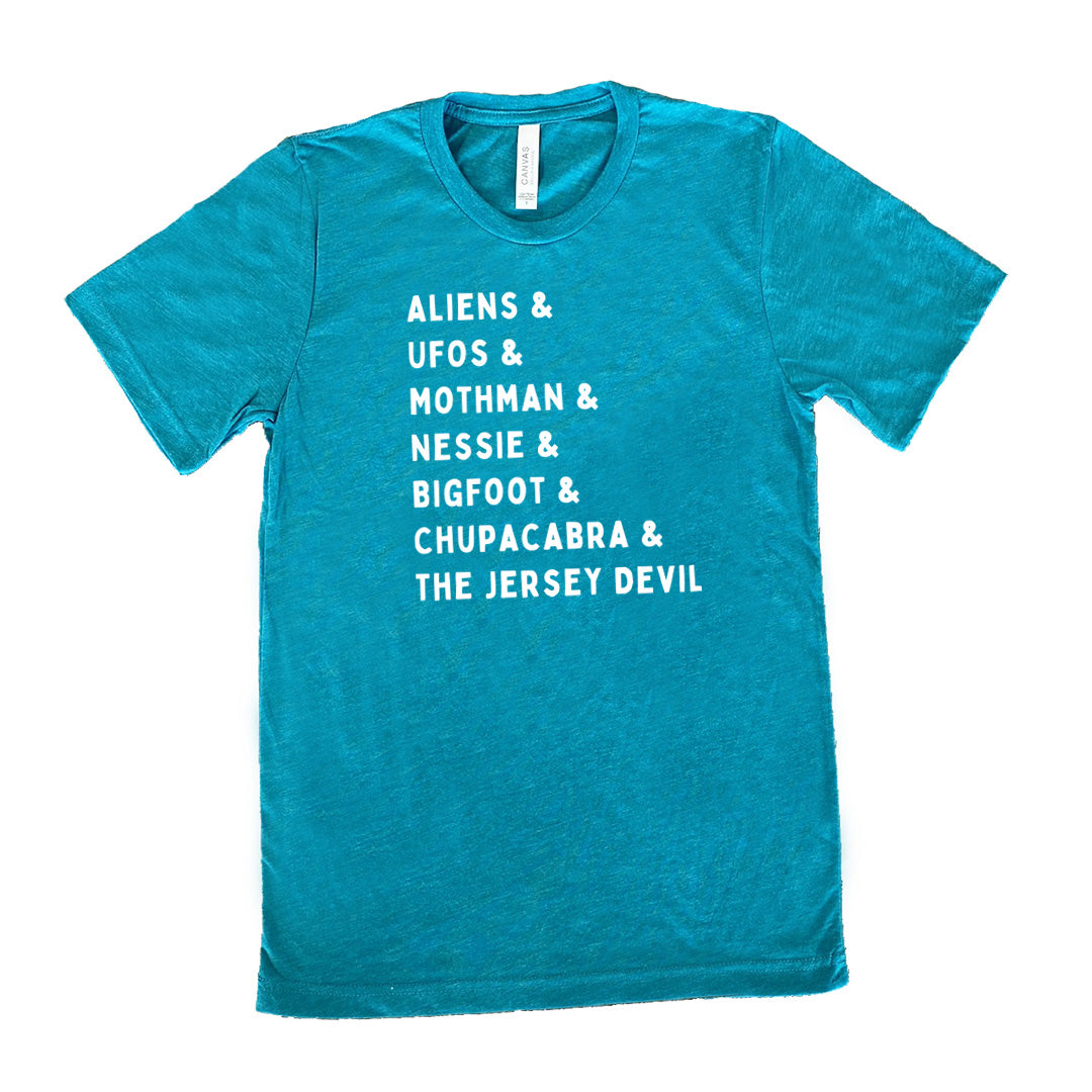 Teal colored shirt with graphic on it that says "ALIENS & UFOS & MOTHMAN & NESSIE & BIGFOOT & CHUPACABRA & THE JERSEY DEVIL"