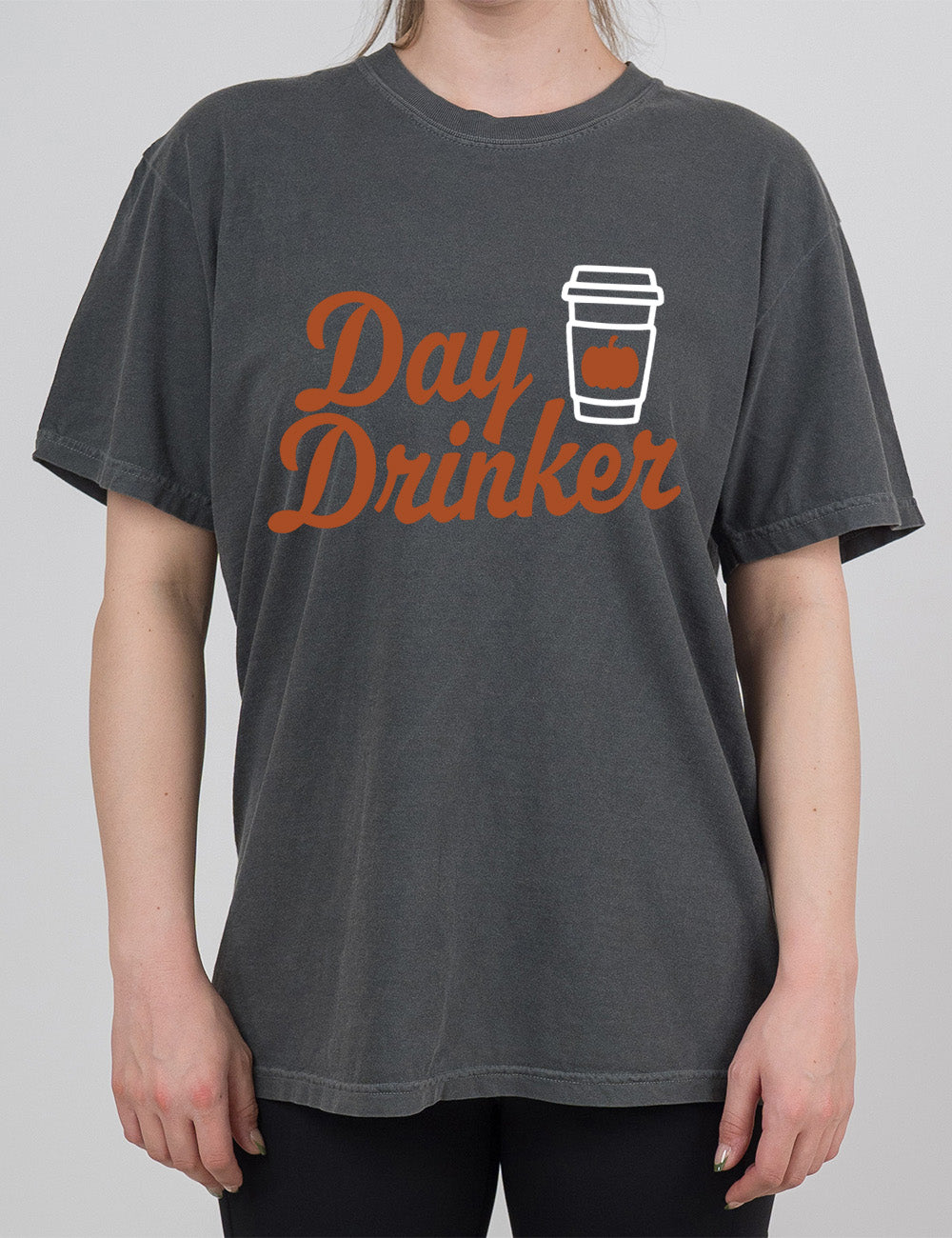 pepper modern tee with the words "day drinker" on it, with the graphic of a takeaway coffee cup with a pumpkin on the cup's sleeve