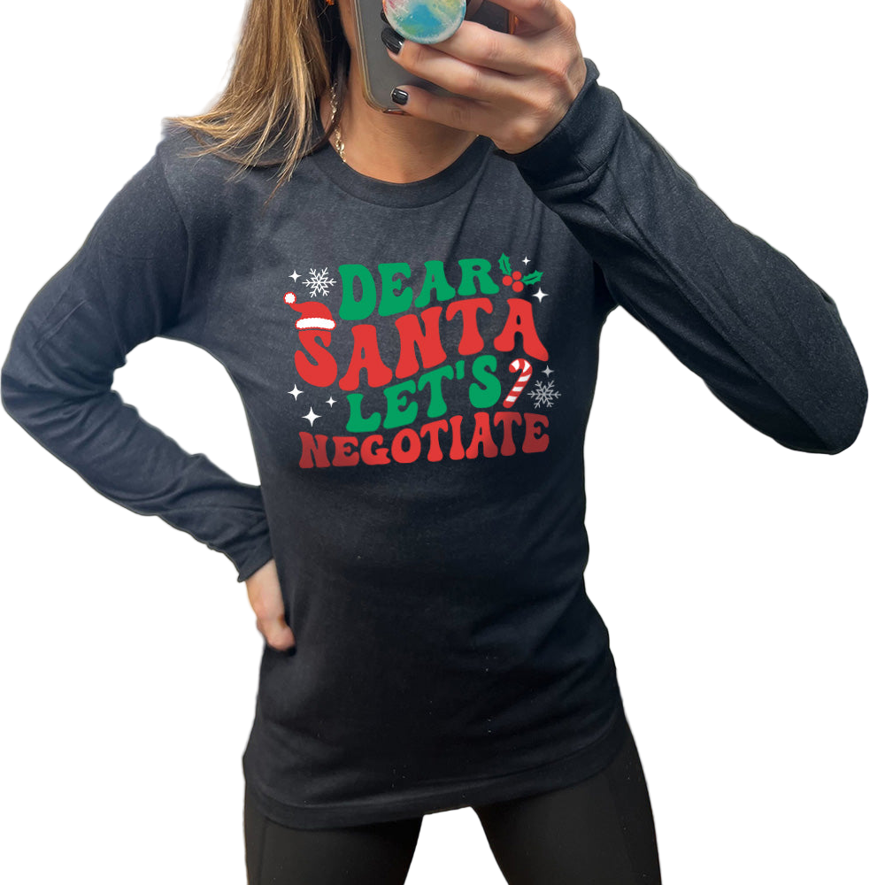 Person wearing a black long-sleeve shirt with Christmas-themed text, standing indoors.