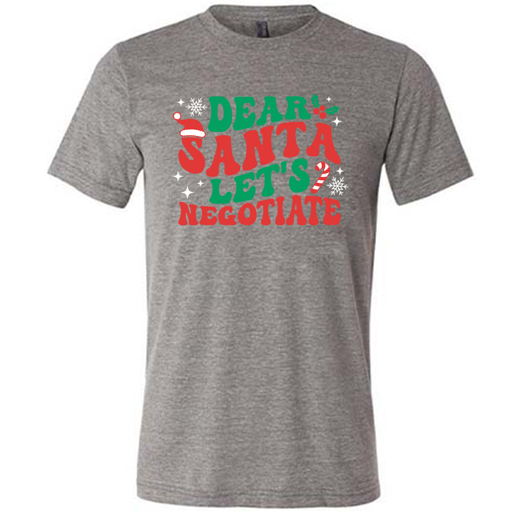 grey unisex tee with the words "dear Santa let's negotiate" with some snowflakes, stars, and a candy cane