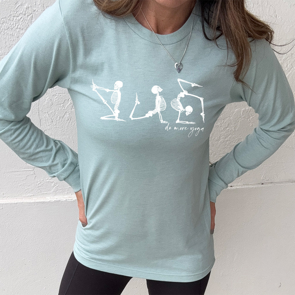 heather dusty blue long sleeve shirt with three skeleton graphics doing yoga, with the small words underneath saying "do more yoga"