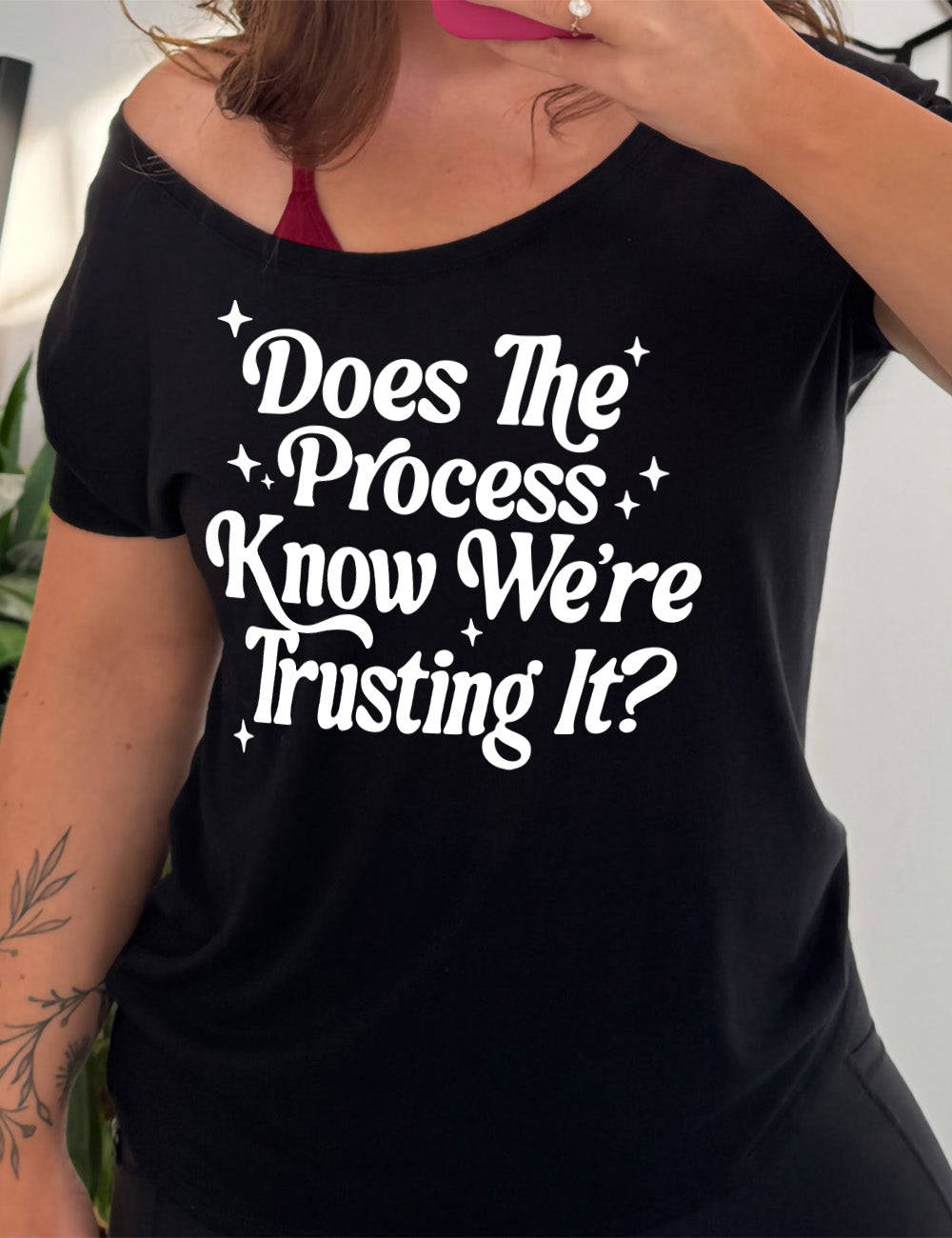 black slouchy tee with the words on it saying "does the process know we're trusting it?" with stars accenting around