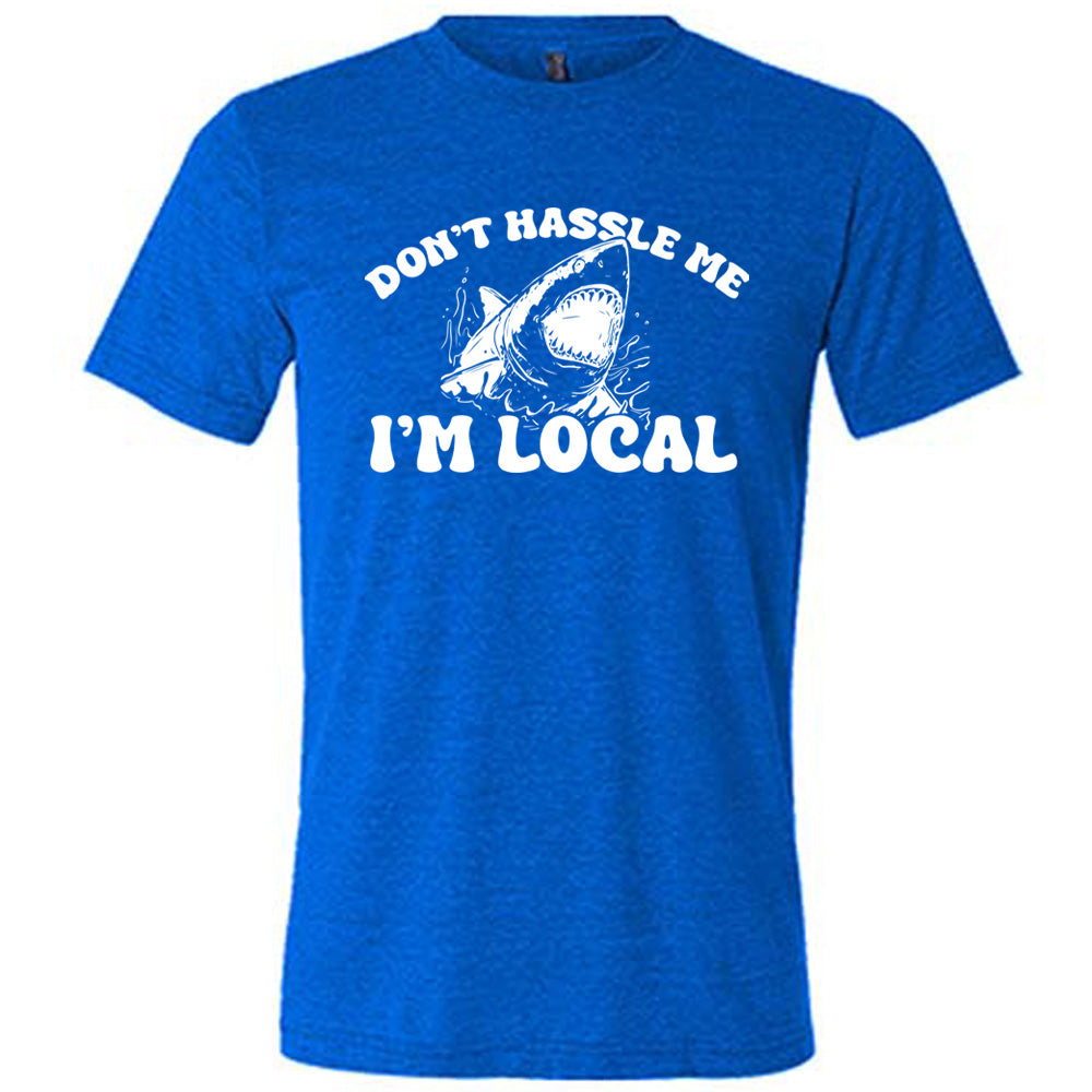 Blue colored shirt with a shark graphic on it that says "Don't Hassle Me I'm Local" 