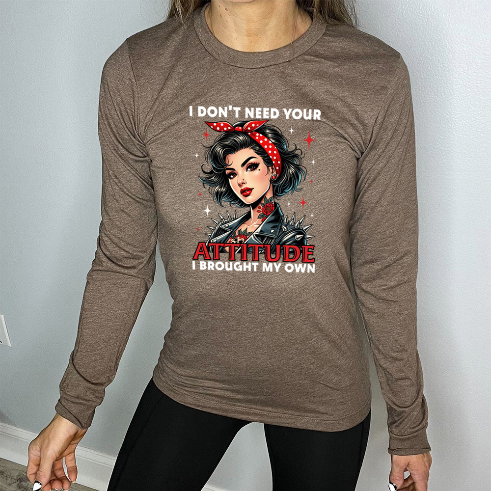 heather brown long sleeve shirt with the text "I Don't Need Your Attitude I Brought My Own" on it, with the graphic of a biker-style glamorous woman with a headband and tattoos