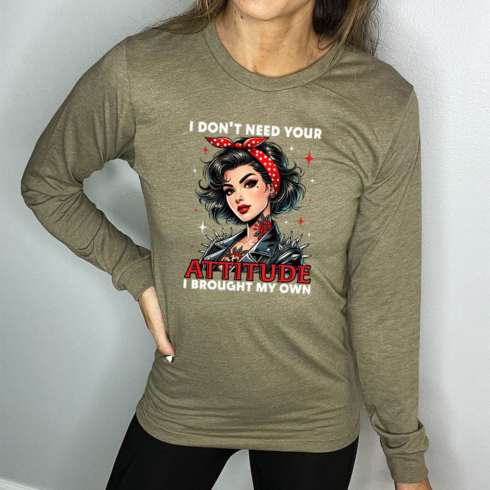 heather olive long sleeve shirt with the text "I Don't Need Your Attitude I Brought My Own" on it, with the graphic of a biker-style glamorous woman with a headband and tattoos