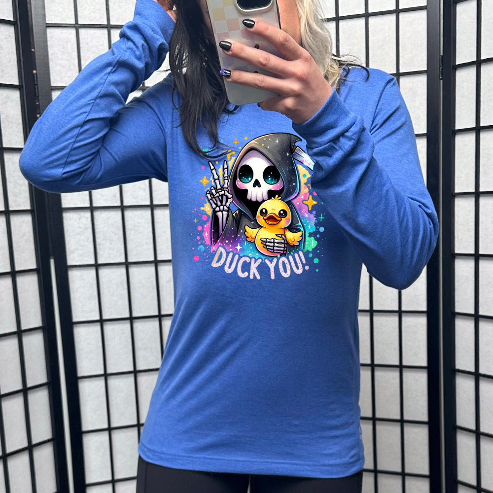 heather true royal long sleeve tee with the text "Duck You!" on it, with the graphic of a cartoon grim reaper, giving the peace sign, and holding a duckling