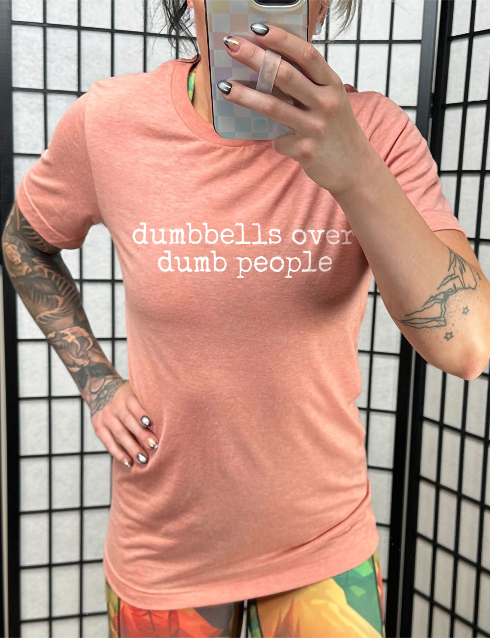 sunset unisex tee with the words "dumbbells over dumb people" on it