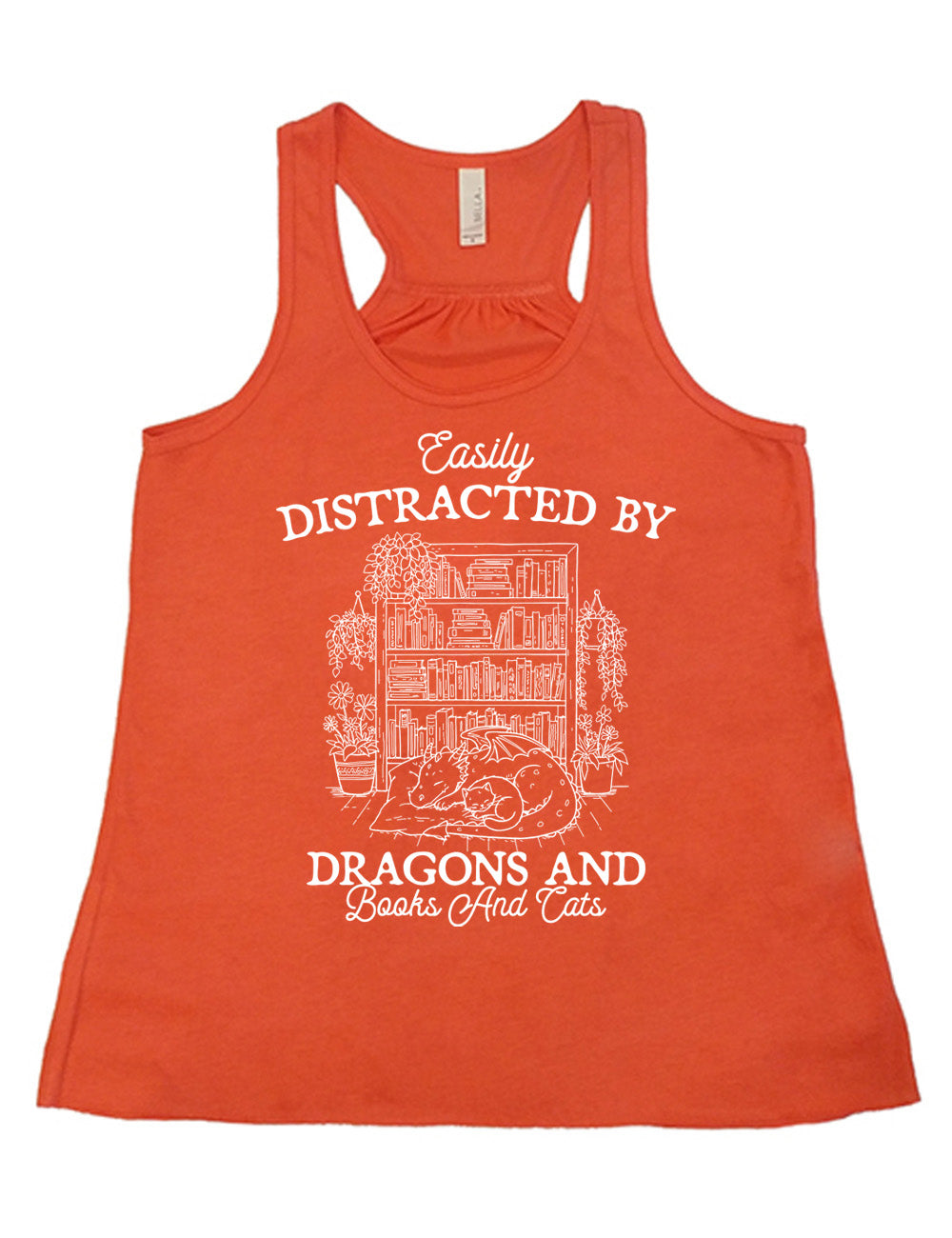 coral flowy racerback tank with words on it saying "Easily distracted by dragons and books and cats" around the graphic of a detailed large, full bookcase, with plants hanging and placed beside it, and a dragon curled up in front of it