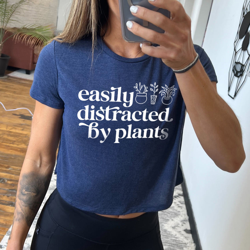 heather navy cropped top with a potted plant graphic on it that says "Easily Distracted By Plants"