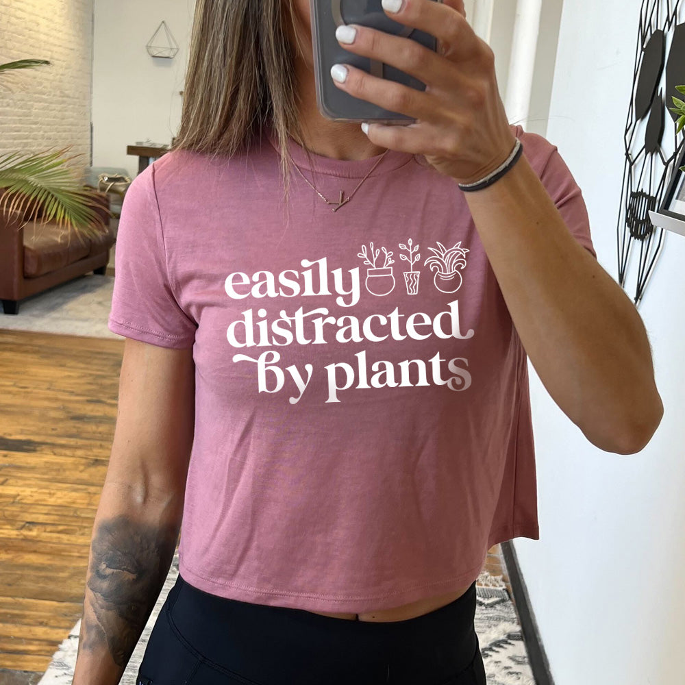 mauve cropped top with a potted plant graphic on it that says "Easily Distracted By Plants"