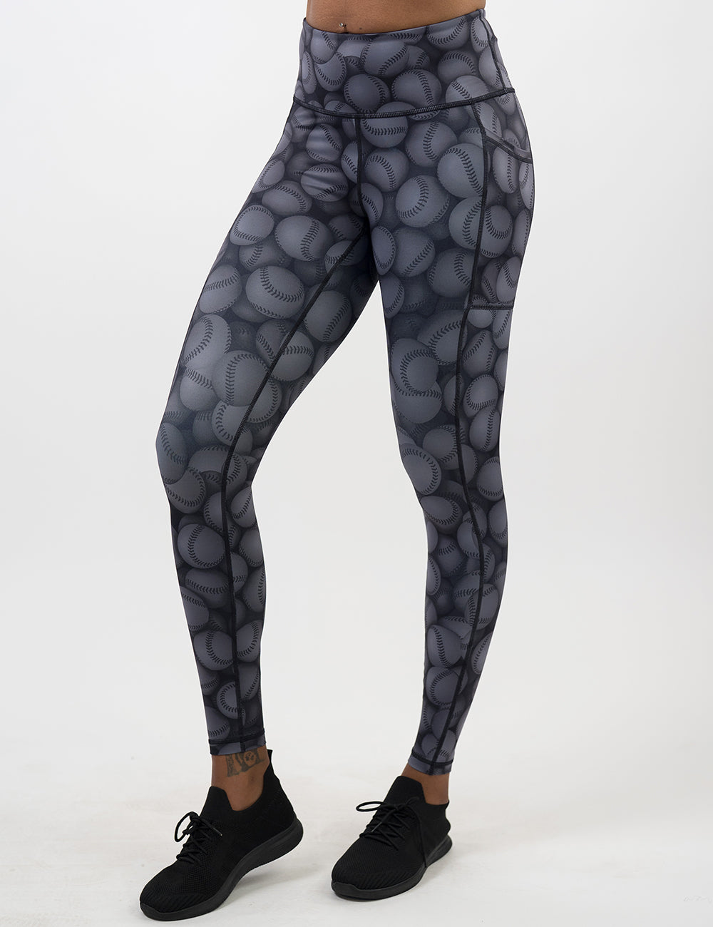 front of the dark grey baseball patterned full length leggings against a white background