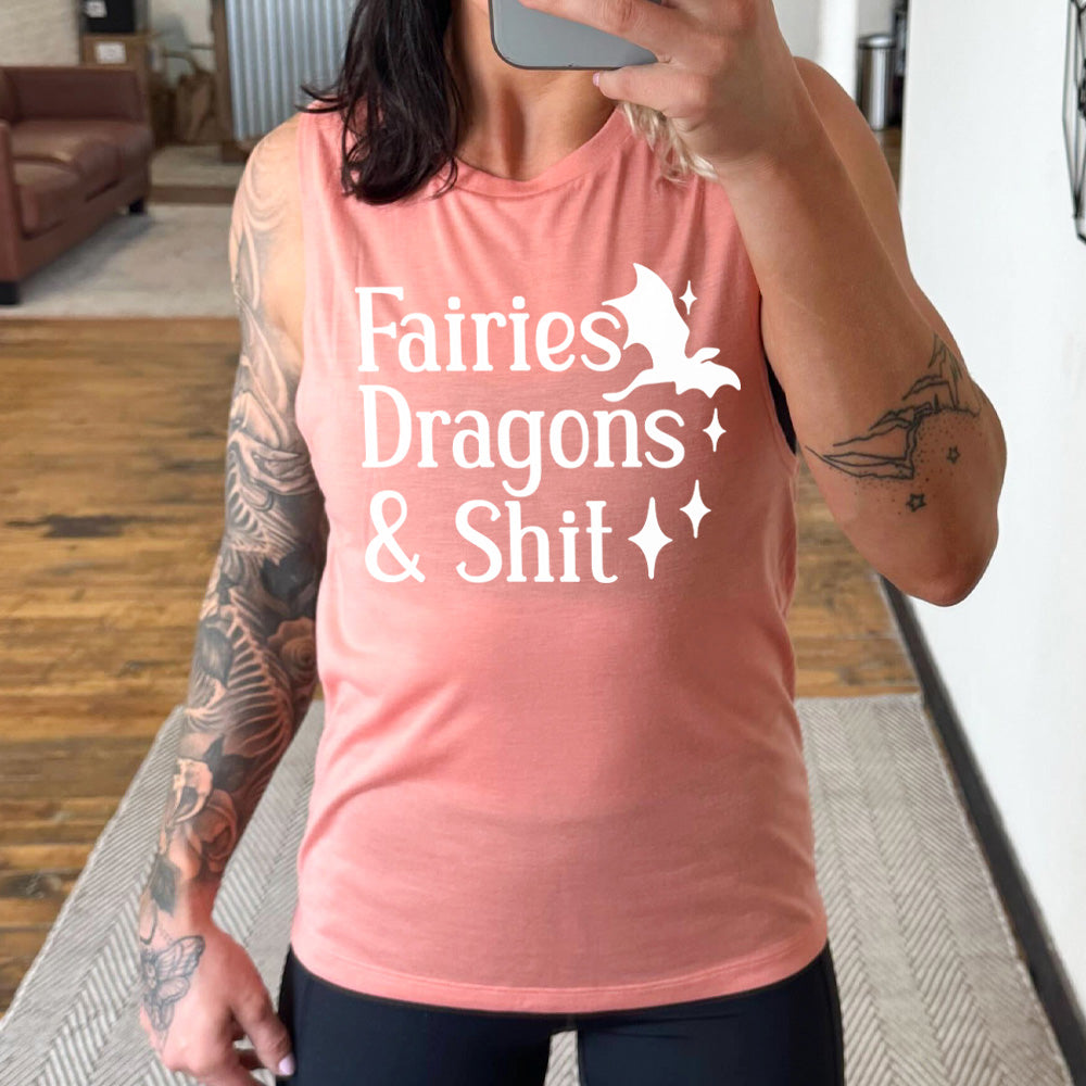 peach muscle tank with the words "fairies dragons & shit" on it, with the small graphic of a dragon and a few stars