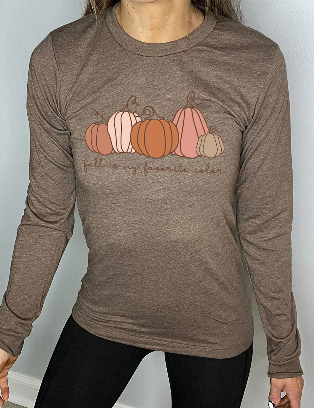 heather brown long sleeve shirt with the graphic of five pumpkins of varied shape and color, and the small words underneath saying "fall is my favorite color"