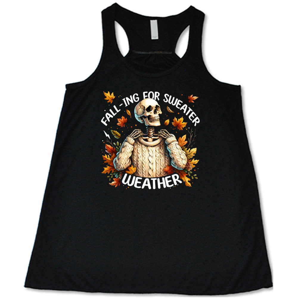 Black colored flowy tank with fall leaves and skeleton wearing a sweater graphic on it that says "Fall-ing For Sweater Weather"
