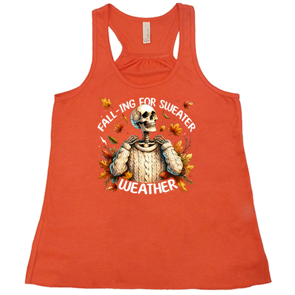 Coral colored flowy tank with fall leaves and skeleton wearing a sweater graphic on it that says "Fall-ing For Sweater Weather"