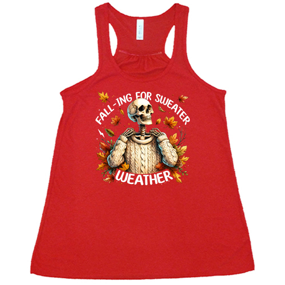 Red colored flowy tank with fall leaves and skeleton wearing a sweater graphic on it that says "Fall-ing For Sweater Weather"