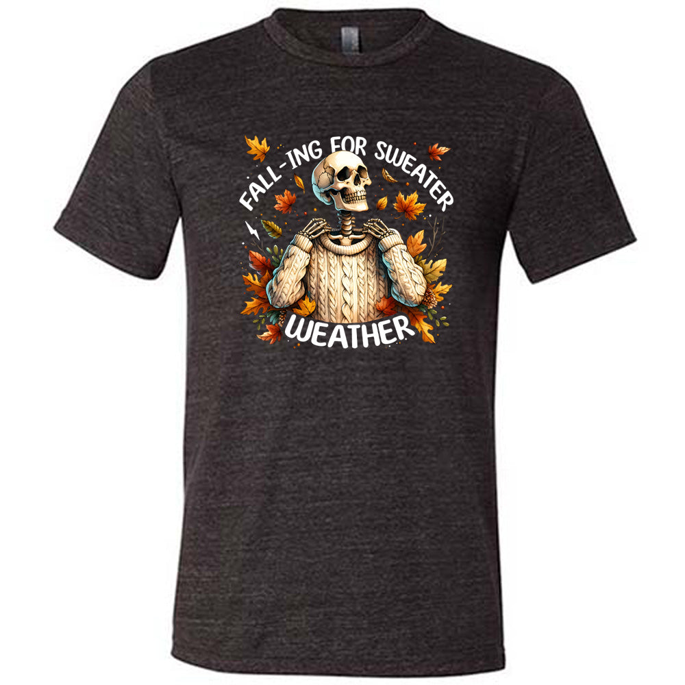 Black colored shirt with fall leaves and skeleton wearing a sweater graphic on it that says "Fall-ing For Sweater Weather"