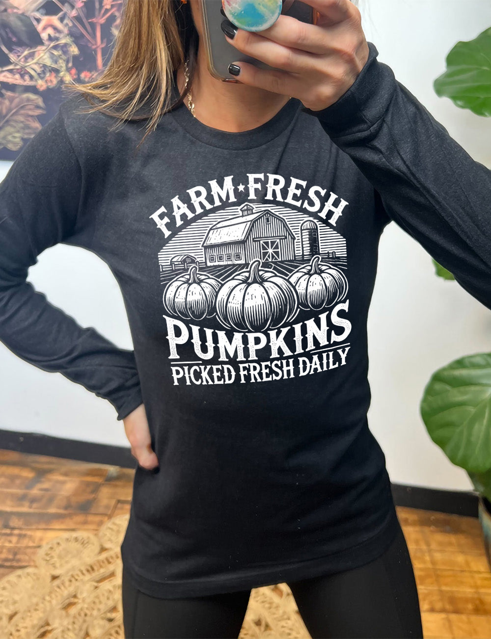 heather black long sleeve shirt with the words "farm fresh pumpkins picked fresh daily" around the graphic of a barn in the background and three pumpkins in the foreground