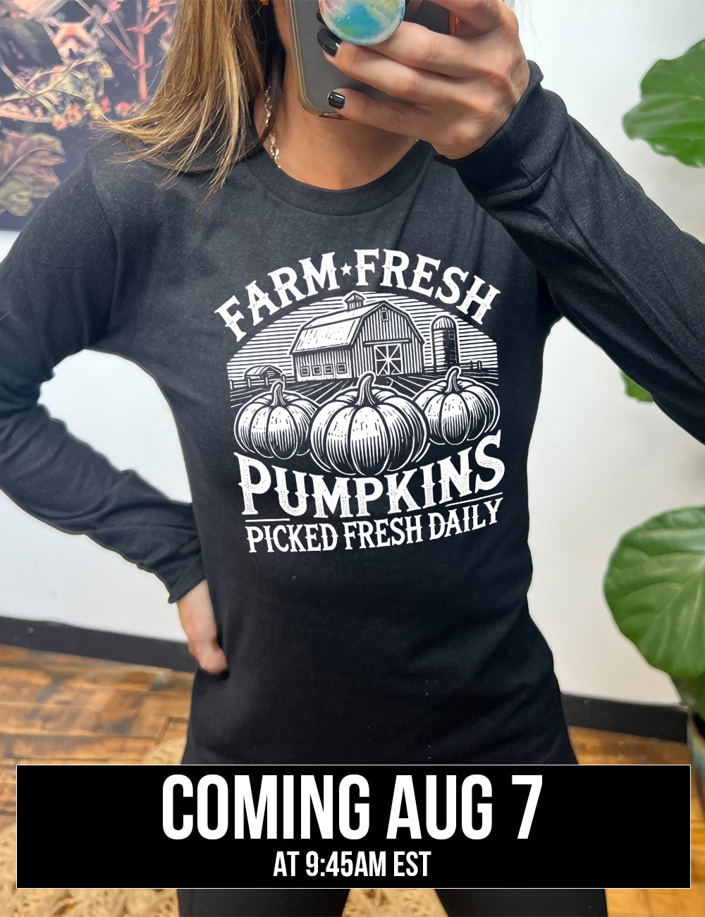 heather black long sleeve shirt with the words "farm fresh pumpkins picked fresh daily" around the graphic of a barn in the background and three pumpkins in the foreground coming august 7th