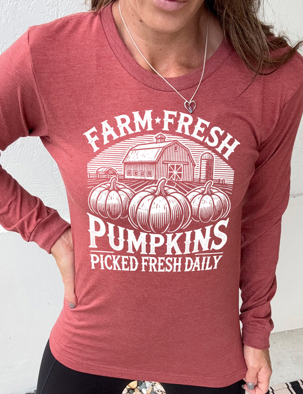 heather clay long sleeve shirt with the words "farm fresh pumpkins picked fresh daily" around the graphic of a barn in the background and three pumpkins in the foreground