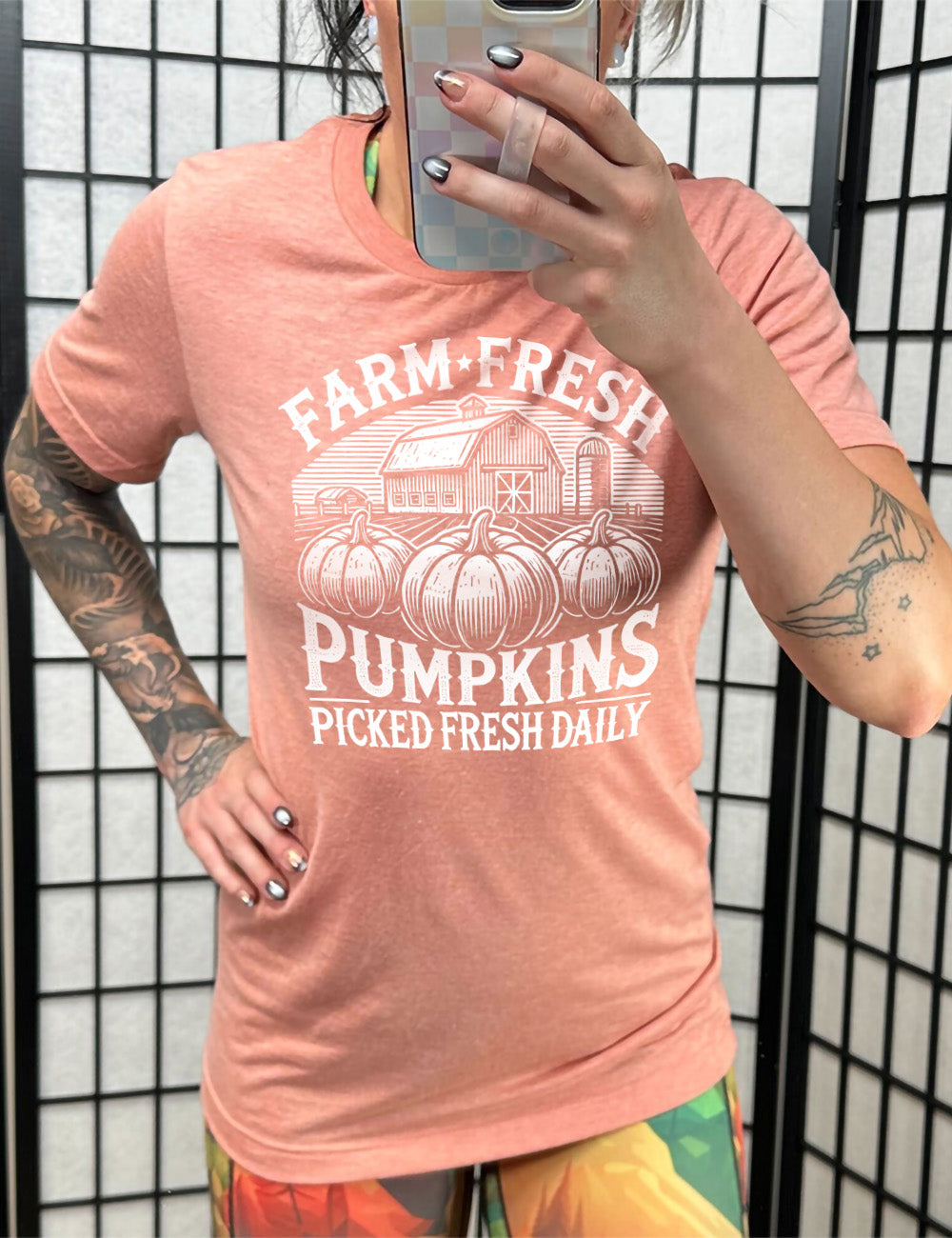 sunset unisex tee with the words "farm fresh pumpkins picked fresh daily" around the graphic of a barn in the background and three pumpkins in the foreground