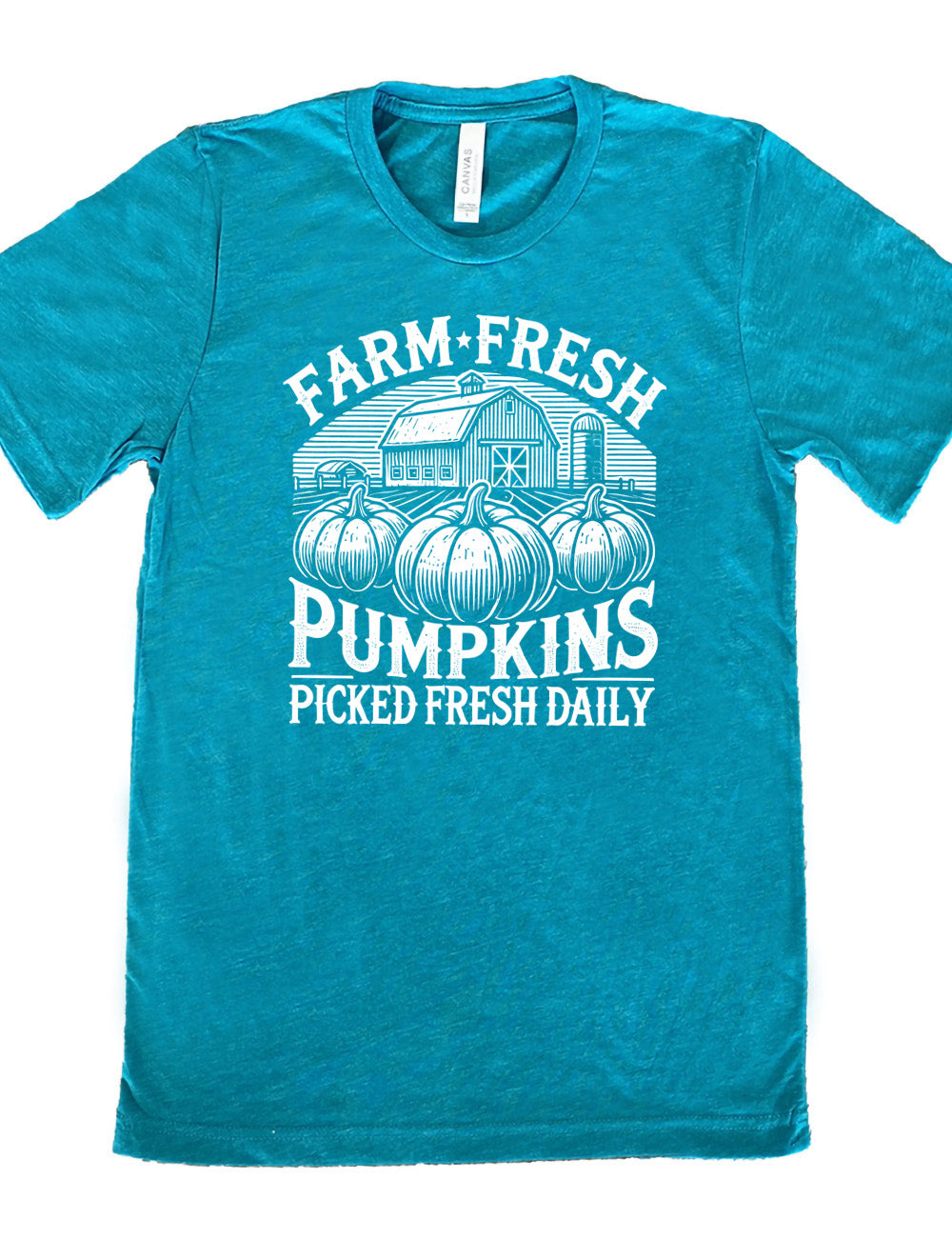 teal unisex tee with the words "farm fresh pumpkins picked fresh daily" around the graphic of a barn in the background and three pumpkins in the foreground