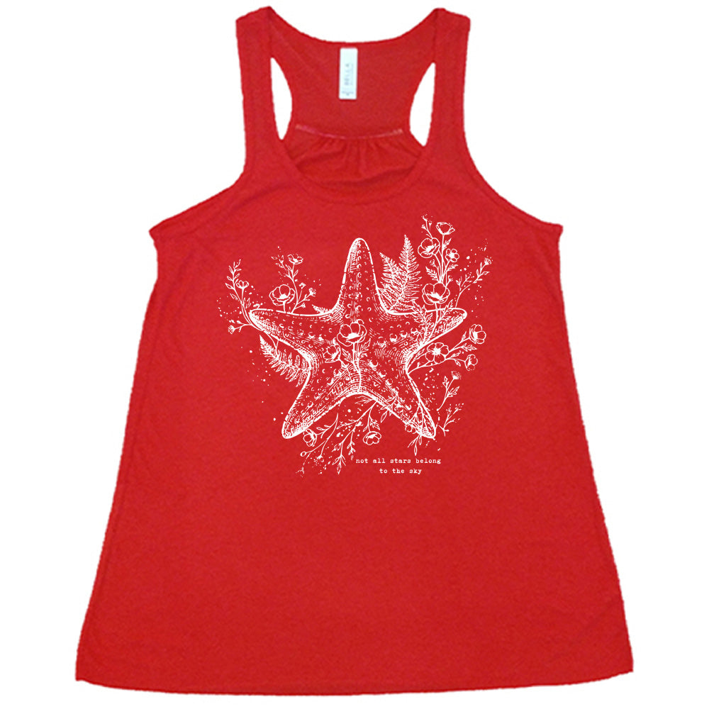 red racerback flowy tank with the graphic of a very detailed starfish among sea plants and flowers, with little bubbles, and the small words underneath it all that say "not all stars belong to the sky"