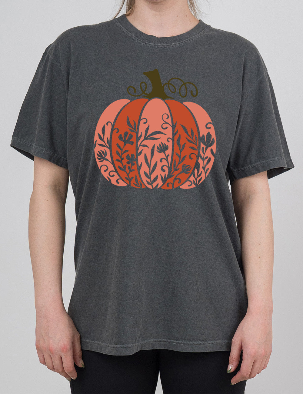pepper modern tee with the colorful graphic of a pumpkin, with vines in silhouette on it