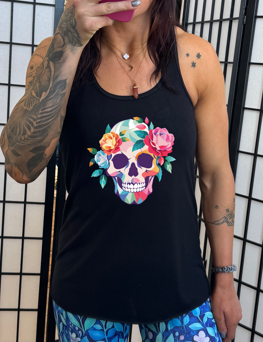 black flowy racerback tank with the colorful graphic of a skull, with flowers adorning it's head