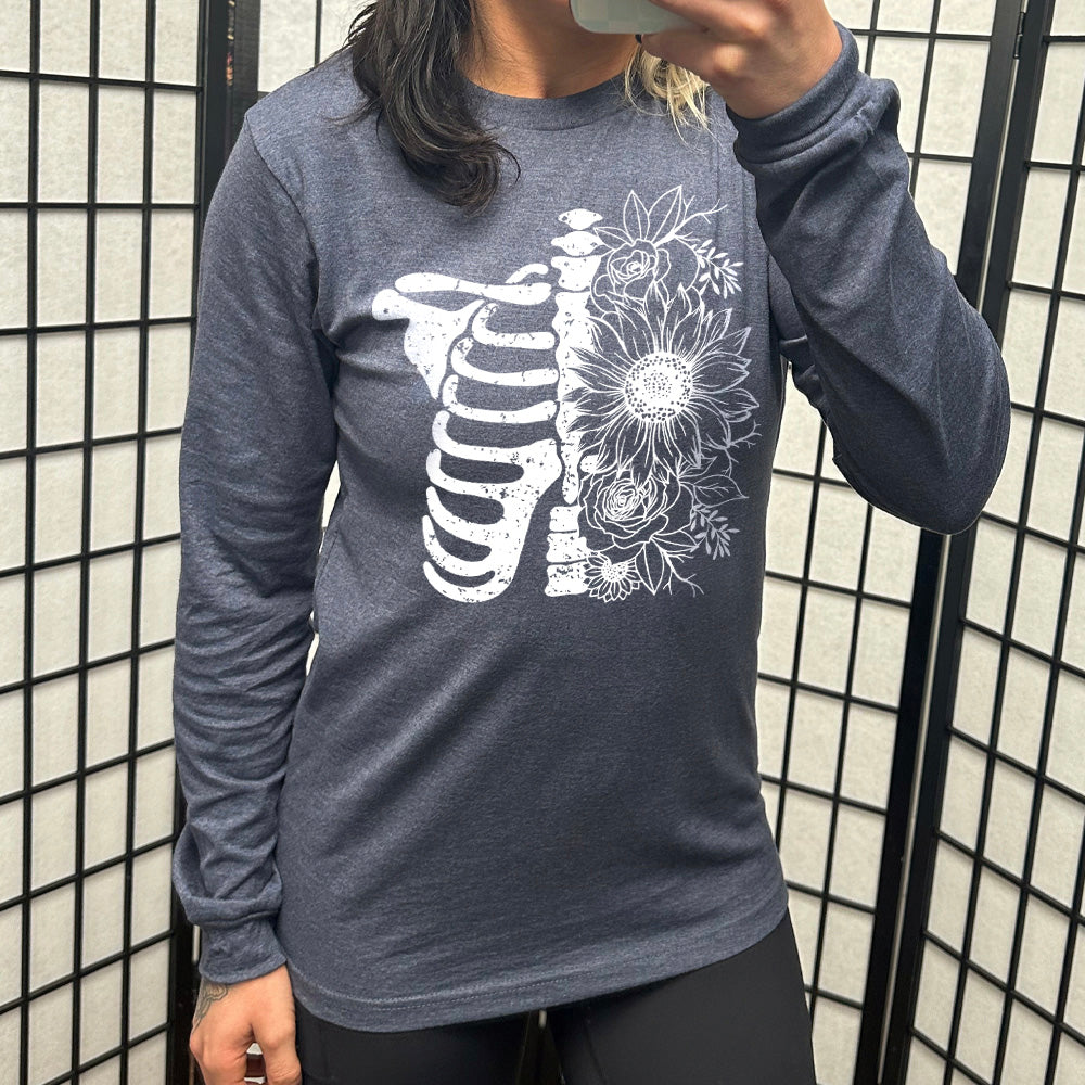 heather navy long sleeve shirt with the graphic of a skeletal ribcage, with half of it being made up of flowers