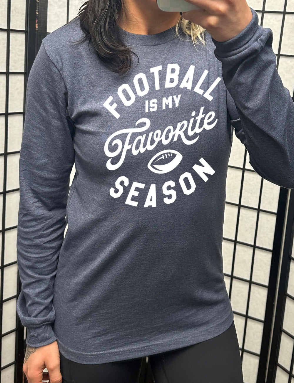 heather navy long sleeve tee with words saying "football is my favorite season" and the small graphic of a football on it 