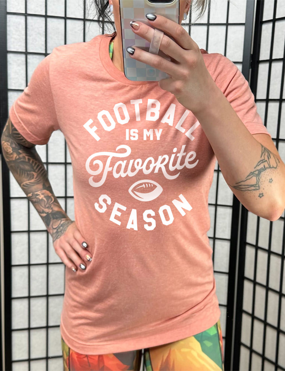 sunset unisex tee with words saying "football is my favorite season" and the small graphic of a football on it 