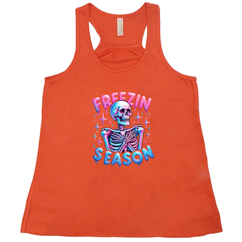 coral shirt with the text "freezin season" with a graphic of a skeleton on it