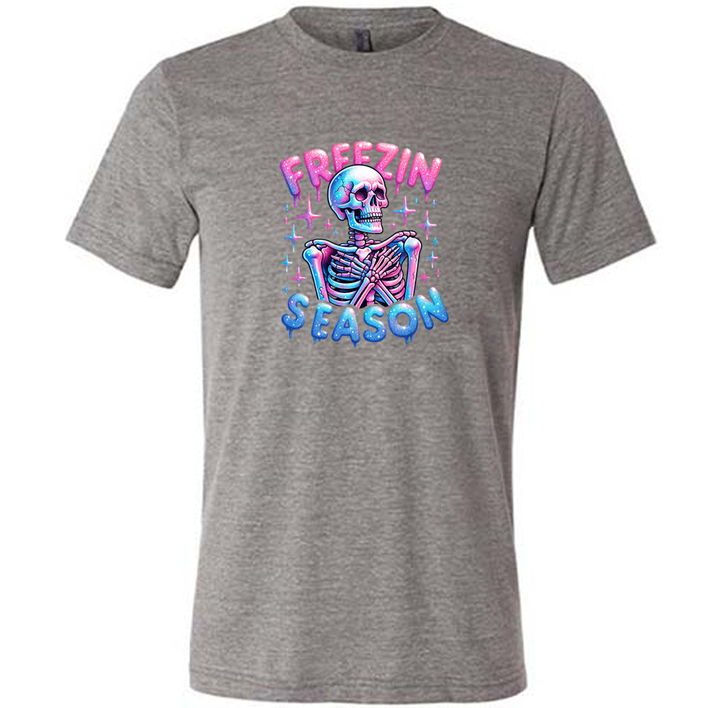 grey shirt with the text "freezin season" with a graphic of a skeleton on it