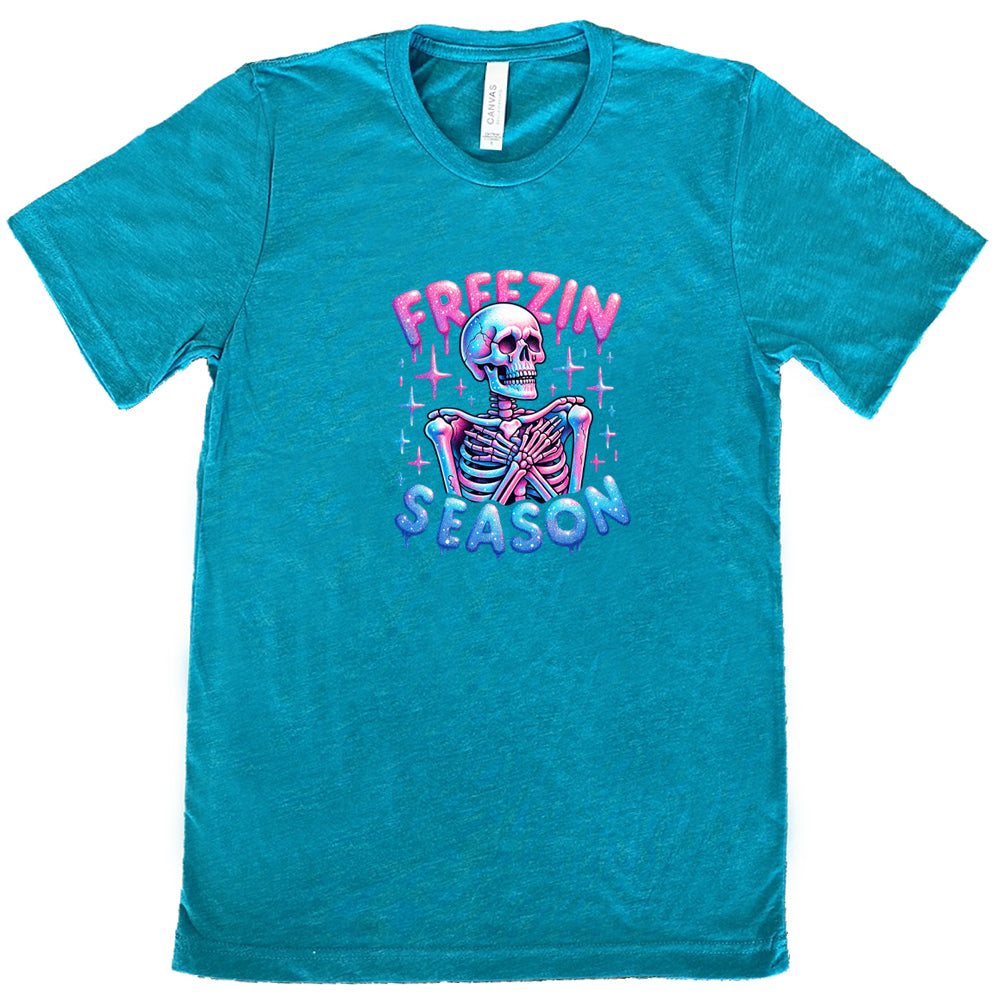 teal shirt with the text "freezin season" with a graphic of a skeleton on it