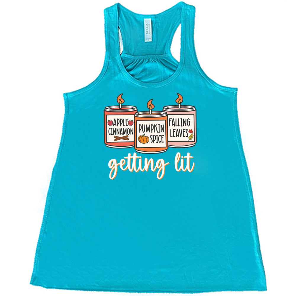 Teal colored flowy tank with fall scented candles graphic on it that says "getting lit" 